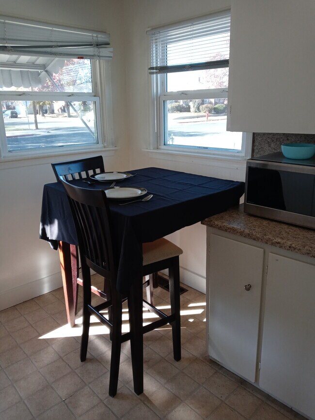 Eat in kitchen with pub table and 2 charis. Bright kitchen, Microwave oven in unit - 564 W 10th St