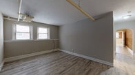 Located at 2773 Hampshire Rd in Cleveland Heights, Ohio, this two-bedroom, one-bathroom residence offers a practical and comfortable single-floor layout. The living room is a standout space, featuring striking exposed brick walls, light hardwood-style flooring, a ceiling fan, and multiple windows that fill the room with natural light, creating a warm and characterful atmosphere.

The kitchen is well-equipped with white cabinetry, a stainless steel range, a black refrigerator, and a sink, all set on clean light tile flooring. Two windows provide ample natural light and views of the surrounding neighborhood. A ceiling fan adds to the room's functionality.

Both bedrooms feature light hardwood-style flooring, neutral gray walls, and windows with blinds that allow for natural light while maintaining privacy. The primary bedroom offers a generous amount of space. Textured ceilings and baseboard heating are consistent throughout the bedrooms.

The hallway connects the rooms efficiently and is finished with light tile flooring and beadboard wainscoting, which continues into the bathroom. The bathroom includes a vanity with a mirror, a toilet, and a tub-shower combination with white surround paneling and a window for ventilation. A dedicated closet completes this well-organized home.