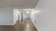 Located at 200 W Columbine Ave in Santa Ana, California, this single-floor residence offers a clean, functional layout with consistent finishes throughout. The open living area is finished with rich wood-style laminate flooring and features a ceiling fan, a large sliding glass door dressed with vertical blinds that allows natural light to pour in, and a mirrored wall that adds depth and brightness to the space. The front entry opens directly into the living area, creating a seamless and accessible flow.

The kitchen is well-appointed with white shaker-style cabinetry, stainless steel countertops, a tile mosaic backsplash in neutral tones, and a window with vertical blinds providing additional natural light. A white refrigerator is included, and the layout maximizes counter and storage space efficiently.

The bedroom features plush wall-to-wall carpeting, a wall-mounted air conditioning unit, and a window that brings in soft, diffused light — creating a comfortable and private retreat.

The bathroom includes a wide vanity with a generous countertop, white cabinetry with ample drawer storage, a large mirror, and a separate shower and bathtub area with wood-style flooring. The textured ceilings are consistent throughout, contributing to the overall cohesive aesthetic of the home.