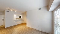 This well-appointed single-floor residence offers two bedrooms and two bathrooms within a thoughtfully designed layout. The interior is defined by a consistent neutral color palette, light wood-style flooring, and an abundance of natural light throughout.

The kitchen is equipped with stainless steel appliances, including a refrigerator, range, and over-the-range microwave. White shaker-style cabinetry pairs with light quartz countertops and a subway tile backsplash, while a pass-through counter connects the kitchen to the living area, enhancing the open feel of the space. The living area provides a comfortable, open layout with track lighting overhead.

Both bedrooms feature ceiling fans with light fixtures, light wood-style flooring, and multiple windows fitted with horizontal blinds that allow for ample natural light and privacy control.

The two bathrooms differ in configuration: one includes a glass-enclosed corner shower with brushed nickel hardware and a single vanity with quartz countertop, while the second features a full tub-shower combination, white tile surround, and a matching white vanity. Both bathrooms maintain a clean, bright aesthetic consistent with the rest of the home.