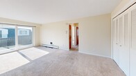 Located at 1950 Sheridan Dr in Buffalo, NY, this single-floor, 3-bedroom, 1-bathroom unit offers a practical and comfortable layout. The living area is spacious and carpeted, bathed in natural light from large windows, and features a ceiling fan and baseboard heating for year-round comfort. The open layout connects seamlessly to the hallway, which leads to the bedrooms and bathroom via warm-toned wood doors. The generously sized primary bedroom offers abundant natural light through wide, blind-fitted windows and includes a full-width louvered bi-fold closet, providing ample storage. The additional bedrooms are similarly carpeted and well-lit, each with baseboard heating. The galley-style kitchen is efficiently designed with warm wood cabinetry, white countertops, a tile backsplash, built-in range and oven, and a sink — all finished with light tile flooring. The bathroom features a clean, all-white tiled tub and shower surround. Throughout the unit, neutral cream-toned walls and plush carpet create a cohesive, understated aesthetic. This unit offers a functional floor plan well-suited for everyday living in a convenient Buffalo location.