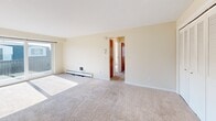 Located at 1950 Sheridan Dr in Buffalo, NY, this single-floor, 3-bedroom, 1-bathroom unit offers a practical and comfortable layout. The living area is spacious and carpeted, bathed in natural light from large windows, and features a ceiling fan and baseboard heating for year-round comfort. The open layout connects seamlessly to the hallway, which leads to the bedrooms and bathroom via warm-toned wood doors. The generously sized primary bedroom offers abundant natural light through wide, blind-fitted windows and includes a full-width louvered bi-fold closet, providing ample storage. The additional bedrooms are similarly carpeted and well-lit, each with baseboard heating. The galley-style kitchen is efficiently designed with warm wood cabinetry, white countertops, a tile backsplash, built-in range and oven, and a sink — all finished with light tile flooring. The bathroom features a clean, all-white tiled tub and shower surround. Throughout the unit, neutral cream-toned walls and plush carpet create a cohesive, understated aesthetic. This unit offers a functional floor plan well-suited for everyday living in a convenient Buffalo location.