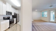 Located at 305 Mohegan Ave in Bluffton, SC, this single-floor, one-bedroom, one-bathroom residence offers a thoughtfully designed layout that maximizes comfort and functionality. The open-concept kitchen is a standout feature, showcasing granite countertops, crisp white cabinetry with beadboard detailing, and a full suite of stainless steel appliances including a refrigerator, electric range, microwave, and dishwasher. Light wood-style flooring runs throughout the kitchen, lending warmth and easy maintenance to the space. The living room flows naturally from the kitchen and is finished with plush wall-to-wall carpeting, neutral white walls, and large windows that invite ample natural light. A glass door provides direct access to a private balcony, enhancing the connection to the outdoors. The bedroom is generously sized, carpeted for comfort, and features a bright window with views of the surrounding neighborhood. The bathroom is finished with granite countertops, white cabinetry, an undermount sink, and a full tub-shower combination, maintaining the cohesive, clean aesthetic found throughout the home. Overall, the residence presents a bright, neutral palette with consistent quality finishes in every room.