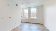Located at 130 S Juniper Street in Philadelphia's vibrant Washington Square West neighborhood, this 2-bedroom, 2-bathroom unit offers a thoughtfully designed single-floor layout. Light wood luxury vinyl plank flooring runs throughout, lending warmth and continuity to the clean, modern aesthetic defined by bright white walls and crisp trim.

The open-concept living and kitchen area serves as the heart of the unit, where recessed lighting illuminates a well-appointed kitchen featuring stainless steel appliances — including a refrigerator, range, and microwave — paired with two-tone cabinetry, white upper cabinets, and wood-finish lower cabinets topped with a light countertop.

Both bedrooms are comfortably sized, with the primary bedroom offering a generous footprint. Natural light filters in through large windows, and each room maintains a neutral, move-in-ready palette. The unit features multiple hallway connections that provide smooth flow between rooms.

The two bathrooms are finished with large-format tile flooring and full subway tile surrounds. One bathroom offers a sleek glass-door walk-in shower, while the second includes a soaking tub with a curved shower rod — both outfitted with wood-tone vanities and brushed nickel hardware, delivering a cohesive, contemporary finish throughout.