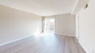 Located at 2900-2915 Seay St in Alexandria, Virginia, this 2-bedroom, 1-bathroom residence offers a practical and comfortable single-floor layout. The combined living and dining area is bright and welcoming, featuring light wood-style luxury vinyl plank flooring and neutral walls that create an airy, open atmosphere. A sliding glass door fills the space with natural light and provides access to a private balcony with outdoor views. The kitchen is efficiently designed with warm cherry-toned cabinetry, light countertops, and a full suite of black appliances, including a range, built-in microwave, dishwasher, and refrigerator. Both bedrooms are carpeted and finished with neutral tones, offering a cozy retreat. The primary bedroom is generously sized and features multiple closets, while the second bedroom includes a window that invites natural light. In total, the residence offers an impressive six closets, providing exceptional storage throughout. The full bathroom includes a tiled tub-and-shower combination with a decorative accent border, a wood-toned vanity with an integrated sink, and tile flooring. The entrance leads conveniently into the main living area, creating a smooth and intuitive flow throughout the home.