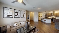 This well-designed single-floor residence offers a thoughtful layout that balances open communal spaces with private retreats. The entryway welcomes you with rich hardwood-style flooring that extends throughout the main living areas, setting a warm and contemporary tone from the moment you step inside.

The living room is a bright, inviting space anchored by a ceiling fan and flanked by large windows dressed with blinds that allow for abundant natural light. Bold abstract artwork adorns the walls, and the open sightlines connect seamlessly to both the kitchen and the hallway leading to the bedroom.

The kitchen is a standout feature, showcasing dark wood-grain cabinetry, a subway tile backsplash, a stainless steel appliance suite, and a wall-mounted range hood. A generous granite-topped island with bar seating serves as a natural gathering point, making the kitchen as functional as it is visually appealing.

The bedroom is a calm, carpeted retreat featuring a ceiling fan, a bright window, and ample space for furnishings. The adjoining bathroom is elegantly finished with a marble-surround soaking tub and shower combination, a granite vanity, and wood-style flooring, creating a clean and spa-like atmosphere.

Throughout the residence, neutral tones, quality finishes, and cohesive design details contribute to a polished, modern living experience.