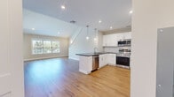 Located at 23 Station Rd in Brookfield, CT, this well-appointed two-story home offers 2 bedrooms and 2 bathrooms across two thoughtfully designed floors. The main level features an open-concept kitchen and living area bathed in natural light from large windows. The kitchen is outfitted with crisp white shaker cabinetry, dark granite countertops, a peninsula with a built-in sink, stylish pendant lighting, and a full suite of stainless steel appliances including a range, microwave, dishwasher, and refrigerator. Light hardwood flooring flows throughout both levels, complementing the home's clean, neutral palette. The living area benefits from vaulted ceilings and abundant natural light, creating an airy, open feel. A multi-paned French door provides additional brightness and outdoor access. The upper level hosts the bedrooms, including a generously sized primary suite with plush carpeting and crown molding. Both bathrooms are well-finished: one features a glass-enclosed walk-in shower and a white vanity, while the second includes a full tub-shower combo and a distinctive navy blue vanity with an LED-lit mirror. A hallway and closet complete the practical layout of this move-in-ready home.