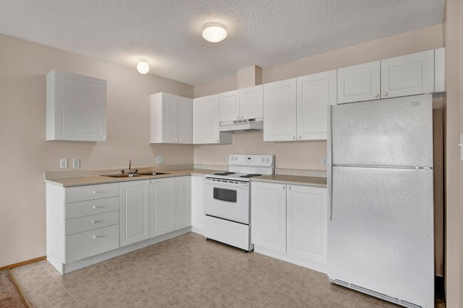 An open kitchen with white cabinets - Aspen Terrace