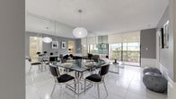 This single-floor residence offers a thoughtfully designed layout with a sleek, contemporary aesthetic carried consistently throughout. The open living and dining area serves as the centerpiece of the space, featuring floor-to-ceiling mirror panels that visually expand the room, white tile flooring, and a crystal globe chandelier suspended above a glass-top dining table with polished chrome seating. Large sliding glass doors flood the area with natural light and open directly onto a private balcony with outdoor views, while an adjacent sitting area provides a comfortable lounge space.

The kitchen is outfitted with white cabinetry, granite countertops, and a full suite of appliances including a range, dishwasher, built-in microwave, and refrigerator, all set against white tile flooring that continues from the main living areas.

Multiple bedrooms are present, each finished with the same white tile flooring and warm neutral wall tones. The primary bedroom is generously proportioned, accommodating a full bedroom suite, while additional bedrooms offer comfortable accommodations with coordinating furnishings. Two bathrooms serve the residence, one featuring a glass-enclosed walk-in shower with beige tile surround, and the other offering a combination tub and shower behind sliding glass doors, both finished cleanly in light, neutral tones.