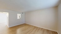 This two-story apartment at 1430 Slate Run Rd in New Albany, Indiana offers a well-organized layout spread evenly across two floors. Light wood laminate flooring runs throughout the home, creating a bright and cohesive aesthetic complemented by neutral, warm-toned walls and white trim.

The main level features a living area with a pass-through window connecting to the kitchen, a dedicated dining room with a stylish pendant light fixture, and a convenient half bathroom finished with a white vanity, brushed nickel fixtures, and a mirrored medicine cabinet. The entry area opens to a closet, providing immediate storage upon arrival.

Upstairs, two bedrooms offer comfortable retreats, each equipped with ceiling fans and generous closet space. The primary bedroom is notably spacious and includes dual closets for abundant storage. A tiled bathroom with a walk-in shower and built-in shelving serves the upper level, alongside an additional full bathroom. Textured ceilings are present throughout.

A sliding glass door in one of the rooms floods the space with natural light and provides outdoor access. With six closets in total distributed across the home, storage is a defining strength of this apartment. The clean, move-in-ready condition and practical two-floor design make this a functional and comfortable residence.