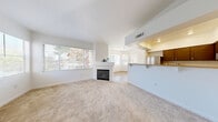 Located at 1350 W Horizon Ridge Pkwy in Henderson, NV, this two-story, 3-bedroom, 2-bathroom residence offers a well-organized and comfortable layout. The main living level features an open-concept design that seamlessly connects the living room, dining area, and kitchen. The living room is bright and airy, filled with natural light from large windows and anchored by a tiled fireplace with a clean white mantel. Soft carpet flooring adds warmth throughout the living spaces. The kitchen is well-appointed with dark cabinetry, granite-style countertops, stainless steel appliances including a refrigerator, gas range, microwave, and dishwasher, and wood-look flooring. A pass-through counter connects the kitchen to the dining area. The spacious primary bedroom features vaulted ceilings, plush carpet, a walk-in closet, and access to a private balcony overlooking the surrounding landscape. The primary bathroom includes a soaking tub, a separate glass-enclosed shower, and dark wood vanity. The secondary bathroom offers a combined tub/shower and matching vanity. Additional highlights include a dedicated laundry area, ample closet storage throughout, a staircase connecting both levels, and an attached garage with an automatic opener.