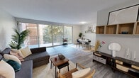 Located at 2300 Marion Barry Ave SE in Washington, DC, this one-bedroom, one-bathroom unit offers a thoughtfully laid-out single-level floor plan that makes efficient use of its space. The combined living and dining area serves as the heart of the home, bathed in natural light from large sliding glass doors that open onto a private balcony with tree-lined views. The living area features sleek hardwood-style flooring and neutral gray walls, creating a clean, modern aesthetic. The dining area is defined by the same flooring and includes a decorative wall shelf, adding a personalized touch.

The kitchen is equipped with warm honey-toned wood cabinetry, marble-style countertops, a gas range, and full-sized white appliances, providing ample storage and prep space. Hardwood-style flooring continues seamlessly throughout this area.

The generously sized bedroom is carpeted for comfort and features a sliding glass door providing additional outdoor access and natural light. A textured ceiling and soft, neutral tones contribute to a calm, restful atmosphere.

The bathroom includes a full tub-shower combo with white tile surround, complemented by clean, simple fixtures. Two hallways connect the rooms, ensuring a smooth and functional flow throughout the unit.