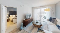 Located in the vibrant Hyde Park neighborhood of Tampa, FL, this thoughtfully designed residence offers a seamless blend of modern aesthetics and functional living. The open-concept living area features light wood flooring, soft neutral tones, and large sliding glass doors that invite natural light and provide access to an outdoor space. The living room is anchored by a warm, coastal-inspired palette with accent walls in muted blue-gray, creating a relaxed yet refined ambiance.

The contemporary kitchen is a standout feature, showcasing sleek two-tone cabinetry — combining warm wood-grain lowers with high-gloss upper cabinets — paired with quartz countertops, stainless steel appliances, and a peninsula with bar seating. A secondary kitchenette or wet bar area features an undermount stainless sink and matching quartz surfaces.

Multiple bedrooms offer plush carpeting, ceiling fans, and generous natural light through large windows dressed with sheer curtains and blinds. Each bedroom provides a calm, comfortable retreat. The bathrooms are finished in a clean, modern style with large-format tile, soaking tubs, illuminated mirrors, and wood-tone vanities with quartz countertops, reflecting a consistent design language throughout the residence.