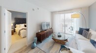 Located in the vibrant Hyde Park neighborhood of Tampa, FL, this thoughtfully designed residence offers a seamless blend of modern aesthetics and functional living. The open-concept living area features light wood flooring, soft neutral tones, and large sliding glass doors that invite natural light and provide access to an outdoor space. The living room is anchored by a warm, coastal-inspired palette with accent walls in muted blue-gray, creating a relaxed yet refined ambiance.

The contemporary kitchen is a standout feature, showcasing sleek two-tone cabinetry — combining warm wood-grain lowers with high-gloss upper cabinets — paired with quartz countertops, stainless steel appliances, and a peninsula with bar seating. A secondary kitchenette or wet bar area features an undermount stainless sink and matching quartz surfaces.

Multiple bedrooms offer plush carpeting, ceiling fans, and generous natural light through large windows dressed with sheer curtains and blinds. Each bedroom provides a calm, comfortable retreat. The bathrooms are finished in a clean, modern style with large-format tile, soaking tubs, illuminated mirrors, and wood-tone vanities with quartz countertops, reflecting a consistent design language throughout the residence.