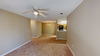 Located at 1330 Shug Jordan Parkway in Auburn, Alabama, this single-story, 3-bedroom, 2-bathroom home offers a functional and comfortable layout. The open-concept living and dining area is a central feature, finished with warm neutral-toned walls, plush carpeting, and a ceiling fan with a light fixture. The space flows naturally toward a chandelier-lit dining area, with the kitchen accessible via a pass-through counter. The kitchen is equipped with black appliances — including an electric range, over-the-range microwave, and refrigerator — complemented by oak cabinetry, light countertops, and tile flooring. The primary bedroom is a well-proportioned retreat featuring French doors that invite natural light and provide outdoor access, along with a walk-in closet outfitted with wire shelving on three walls for ample storage. The two additional bedrooms each feature ceiling fans, carpeted floors, and windows that bring in natural light. The bathrooms are finished with tile flooring, oak vanity cabinetry, and neutral wall tones. Textured ceilings and consistent warm beige walls throughout the home create a cohesive, understated aesthetic.
