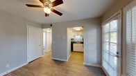 This two-floor residence offers a well-organized layout designed for comfortable everyday living. The main living area features durable wood-look flooring and a ceiling fan with integrated lighting, creating a bright and airy atmosphere. Natural light filters in through slatted blinds, adding warmth to the neutral gray-toned walls. The layout opens directly to a compact, functional kitchen equipped with white cabinetry, dark countertops, a stainless steel sink, and black appliances including a refrigerator, range, and dishwasher. Under-cabinet lighting adds a practical touch to the cooking space.

The bedrooms are comfortably sized, with some featuring soft carpet flooring, ceiling fans, and windows that allow ample natural light. Closet storage is available in select rooms, including built-in shelving. The bathrooms are clean and efficiently designed, each featuring a tub-shower combination with tiled surrounds, white vanities with dark countertops, and wood-look tile flooring. Textured walls are present throughout, lending a classic residential character to the space.

The second floor, accessible via an interior staircase, mirrors the thoughtful layout of the main level, extending the overall living space across a generous footprint suited for a variety of lifestyle needs.