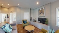 Located at 5811 Spring Run Dr in Columbus, Ohio, this single-floor home offers a comfortable and well-appointed living environment. The living area serves as the focal point of the space, showcasing a striking white brick fireplace that adds both character and warmth to the room. A framed piece of artwork displayed above the fireplace mantel enhances the area's visual appeal, while recessed ceiling lights provide even, ambient illumination throughout. The flooring features rich hardwood-style planks that run throughout the living space, contributing to a warm and inviting atmosphere. Neutral gray walls create a clean, versatile backdrop that complements the room's furnishings and architectural details. The living area is thoughtfully arranged with comfortable seating, including accent chairs with coordinating throw pillows and a round coffee table, encouraging a relaxed and social environment. A large mirror near the entryway adds depth to the space and reflects natural light. The layout is practical and cohesive, with interior doors providing access to additional areas of the home. Overall, this residence combines classic architectural elements with a clean, modern aesthetic to create a welcoming and functional single-floor living space.