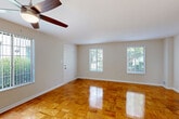 This two-story, two-bedroom, two-bathroom home in Alexandria, Virginia offers a well-organized layout spread across two floors. The main level features a bright, open living and dining area highlighted by beautifully polished parquet hardwood floors that reflect natural light pouring in through multiple windows. Ceiling fans add comfort and airflow throughout the living spaces. The kitchen is thoughtfully designed with rich cherry wood cabinetry, dark granite countertops, stainless steel appliances including a dishwasher, gas range, and refrigerator, and tile flooring. A stacked washer and dryer unit is conveniently integrated within the kitchen area. A hallway off the kitchen leads to a second bathroom featuring a pedestal sink and clean, neutral finishes. Upstairs, the two bedrooms offer warm hardwood flooring, generous closet space, and windows with outdoor views of surrounding greenery. The primary bedroom provides a comfortable, well-proportioned retreat. The bathrooms are finished with granite-topped vanities, tile flooring, and white subway tile surrounds. With four closets throughout and a utility room, this home offers ample storage. The layout is functional, well-lit, and move-in ready.