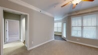 Located at 1122 Cranbrook Dr in Asheville, NC, this single-floor, one-bedroom, one-bathroom residence offers a well-organized and functional layout. The space is finished with neutral gray walls, white trim, and crown molding throughout, creating a clean and cohesive aesthetic.

The galley-style kitchen is a standout feature, equipped with stainless steel appliances including a gas range, refrigerator, microwave, and dishwasher. White shaker-style cabinetry pairs with granite countertops and wood-look flooring, giving the kitchen a polished, modern feel. An opening from the kitchen leads directly to the dedicated laundry room, which accommodates a full-size washer and dryer.

The bedroom is a comfortable, carpeted retreat featuring crown molding, a ceiling fan with light fixture, and multiple windows that allow for generous natural light and views of the surrounding greenery. Adjacent to the bedroom is a walk-in closet outfitted with wire shelving and hanging rods, offering ample storage.

The bathroom includes a full tub-shower combination with white tile surround accented by a bold green tile border stripe, complemented by wood-look flooring. Additional spaces include an entrance, hallway, and dedicated closet, rounding out this efficiently designed Asheville residence.