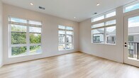 Located at 35 Flax St in Delaware, Ohio, this thoughtfully designed 2-bedroom, 2-bathroom home offers a clean, contemporary aesthetic with high-quality finishes throughout. Light hardwood flooring flows across the main living areas, complemented by crisp white walls and recessed lighting that create a bright, airy atmosphere.

The open-concept kitchen and living area serves as the heart of the home, featuring a large center island with a white quartz countertop and a matte black faucet, white shaker cabinetry, subway tile backsplash, stainless steel appliances, and pendant lighting overhead. A door from the living area provides direct access to the balcony, offering views of the surrounding neighborhood.

The primary bedroom is a well-proportioned retreat with multiple windows that invite abundant natural light and treetop views. Both bedrooms are finished with neutral carpet for comfort. The bathrooms are elegantly appointed — one features a long double-vanity with white countertops, dual undermount sinks, chrome fixtures, and sleek black-framed mirrors. The second bathroom offers a similarly refined, minimalist design.

Additional highlights include four closets, a dedicated laundry area, a pantry, and a welcoming entrance. The overall ambiance is modern, clean, and move-in ready.