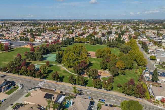 This park is spacious with green grass, play structure, and tennis courts.
