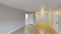 Located at 5806 S Alameda St in Corpus Christi, Texas, this single-floor unit offers a clean, modern aesthetic throughout its well-organized layout. The interior is unified by light wood-look flooring and soft blue-gray walls paired with crisp white trim, creating a calm and cohesive atmosphere across all rooms.

The living area is bright and open, benefiting from multiple windows that allow natural light to fill the space. A ceiling fan adds both function and a finishing touch to the room. The layout flows naturally into a hallway connecting the various areas of the unit.

The kitchen is efficiently designed with white cabinetry offering ample storage, dark countertops, and white appliances including a range and refrigerator. A built-in pantry area with open shelving adds additional storage flexibility.

The bedroom provides a quiet, versatile space with the same cohesive flooring and wall tones seen throughout the unit. The bathroom is a standout feature, showcasing large-format marble-style wall tiles surrounding the bathtub and shower area, complemented by overhead cabinetry for additional storage. The wood-look flooring extends into this space, maintaining a consistent design language.

Overall, the unit presents a tidy, move-in-ready environment with thoughtful details and a neutral palette that offers a welcoming feel.