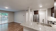Located at 3000 Shadowood Pkwy SE in Atlanta, GA, this well-appointed 2-bedroom, 2-bathroom residence offers a thoughtfully designed single-level layout. The open-concept kitchen and living area serves as the heart of the home, featuring rich dark-wood cabinetry, granite countertops, stainless steel appliances including a refrigerator, range, and microwave, and a peninsula with an integrated sink — ideal for both cooking and casual dining. Hardwood-style flooring flows throughout the main living areas, adding warmth and visual continuity. The living room opens directly to a private balcony through sliding glass doors, offering peaceful outdoor views of surrounding greenery. Both bedrooms are generously sized and finished with plush carpeting and ceiling fans for year-round comfort. The spacious primary bedroom includes a walk-in closet with wire shelving systems for organized storage. The bathrooms are clean and functional, with one featuring a full soaking tub and shower combo with built-in shelving. Additional highlights include a dedicated laundry area, pantry, utility room, and multiple closets throughout, ensuring practical storage solutions across the entire residence.