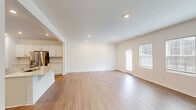 Located at 449 Lettie Ln in Rolesville, NC, this two-story home offers four bedrooms, five bathrooms, and a well-designed layout spread across two floors. The main level features an open-concept living room and kitchen, filled with natural light from large windows and finished with smooth hardwood-style flooring throughout. The kitchen is outfitted with crisp white shaker cabinets, quartz countertops, a subway tile backsplash, and stainless steel appliances, including a refrigerator, range, and microwave. A pedestal sink half-bath on the main floor adds convenience for guests. A staircase with dark wood treads, white risers, and sleek black balusters connects the floors with a refined, contemporary touch. The upper level houses all four bedrooms, including a spacious primary suite with a walk-in closet equipped with wire shelving. Additional bedrooms feature plush carpeting and bright windows offering neighborhood views. A dedicated laundry room on the upper level includes a full-size washer and dryer with overhead storage shelving. The home also includes an attached garage with an automatic opener. Clean finishes, recessed lighting, and a neutral palette throughout give this home a modern, move-in-ready feel.