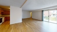 Located at 37 Village Cir in Milford, Massachusetts, this single-floor residence offers a practical and well-organized layout with a clear separation between living and sleeping areas. The floor plan, as revealed by the 3D model, divides the space into distinct zones connected by interior hallways.

The main living area is generously sized and features light wood-toned laminate flooring that extends throughout the common spaces. Neutral white walls and a textured ceiling contribute to a bright, open atmosphere. A sliding glass door provides access to the outdoors, allowing natural light to fill the room. An adjacent open area offers additional flexibility for dining or additional living arrangements.

The kitchen is equipped with warm oak cabinetry spanning both upper and lower sections, offering ample storage. Light countertops complement the cabinetry, and appliances include an electric range, dishwasher, and refrigerator. The kitchen also features a single-basin sink and hardwood-style flooring.

The bedrooms are carpeted in a neutral tone, providing a softer underfoot feel, and include closet space. The bathroom is finished in white with a vanity cabinet, wall mirror, and a full tub-shower combination, maintaining a clean and functional aesthetic throughout.