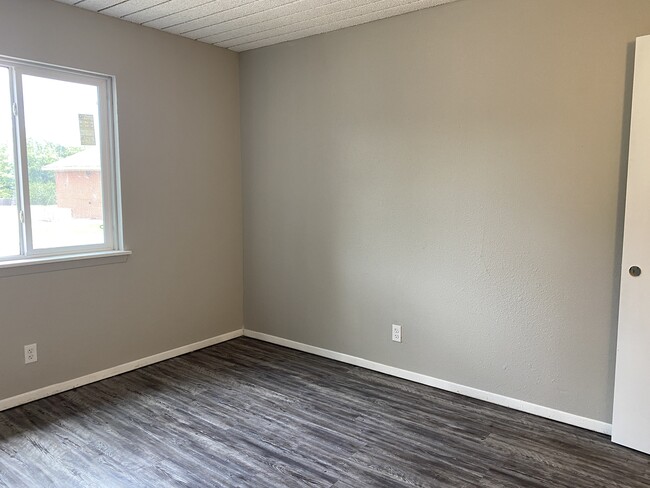 Spacious living room features faux wood flooring and window treatments. - Midtown Park Apartments