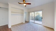 This well-appointed 2-bedroom, 2-bathroom single-floor residence in Fort Worth, TX, offers a thoughtfully designed layout with a welcoming entrance and a hallway connecting the key living spaces. The open living room serves as the heart of the home, showcasing rich hardwood-style flooring, crown molding, a ceiling fan, and a classic white-mantled fireplace flanked by built-in shelving — ideal for display or storage. Large French doors with transom windows flood the space with natural light and provide outdoor access. The kitchen is equipped with stainless steel appliances, including a range, microwave, dishwasher, and refrigerator, complemented by granite countertops, a dark subway tile backsplash, and crisp white shaker cabinetry. Both bedrooms feature plush wall-to-wall carpeting, ceiling fans, and windows that bring in ample natural light, with the primary bedroom offering direct outdoor access via a private door. Three closets provide generous storage throughout. The bathrooms are finished with granite-topped white vanities and hardwood-style flooring. The exterior features a stone perimeter wall with iron fencing, adding character to the outdoor surroundings.