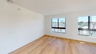 This contemporary apartment in North Miami offers a blend of comfort and style across its 990 square feet. The space is efficiently designed with four bedrooms, including a generous 210 square foot primary bedroom, and two well-appointed bathrooms. The open-concept living area seamlessly integrates the kitchen and living room, creating a spacious feel.

The kitchen is a highlight, featuring sleek cabinetry in light tones, stainless steel appliances, and a convenient center island. Track lighting adds a modern touch, while natural light floods in through large windows. Hardwood floors run throughout, lending warmth to the crisp white walls.

The bathrooms are luxuriously appointed with marble-like tiling, featuring a combination of white and golden hues. One bathroom boasts a large vanity with dual sinks and an illuminated mirror, while another includes a shower/tub combination with elegant tiling.

Large windows in the bedrooms offer city views and ample natural light. The apartment is part of a modern complex with impressive amenities, including a expansive pool area with lounge chairs and tropical landscaping. The building's exterior showcases a contemporary design with balconies and blue accents.

This unit offers a perfect balance of private spaces and communal areas, ideal for both relaxation and entertaining. Its location in North Miami provides easy access to urban conveniences while maintaining a sense of retreat.