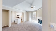 Located at 8025 Ohio Dr in Plano, TX, this well-appointed 2-bedroom, 3-bathroom single-floor residence offers a thoughtfully designed layout with a welcoming entrance that leads into a spacious living area. The living room is highlighted by a classic white-mantled fireplace, a ceiling fan, crown molding, and a glass door that opens to a private balcony overlooking mature trees, allowing for abundant natural light. The kitchen features white shaker cabinetry, white quartz countertops, a beige subway tile backsplash, stainless steel appliances including a dishwasher, and a central island with seating — all complemented by wood-look flooring and a natural light-filled window. Both bedrooms are carpeted and include ceiling fans, with the primary bedroom offering a walk-in closet with wire shelving and an en-suite bathroom complete with a soaking tub, white tile surround, and wood-look flooring. A second walk-in closet serves the additional bedroom. The three bathrooms are clean and functional, each featuring soaking tubs. An in-unit laundry area provides added convenience. Neutral tones and carpet throughout create a cohesive, comfortable ambiance.