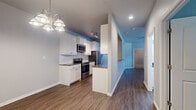 This single-floor, 2-bedroom, 2-bathroom residence offers a functional and well-designed layout that maximizes everyday living. The open living area features hardwood-style flooring, neutral-toned walls, and a ceiling fan, creating a bright and airy atmosphere. A pass-through opening connects the living space to the kitchen, enhancing the sense of openness.

The galley-style kitchen is a standout feature, outfitted with white shaker cabinetry, dark granite countertops, a subway tile backsplash, and a full suite of stainless steel appliances including a range, microwave, refrigerator, and dishwasher. Track lighting and a decorative chandelier add both task and ambient illumination.

Both bedrooms are carpeted for comfort and include ceiling fans. The primary bedroom offers a generous footprint with its own dedicated closet. A second carpeted bedroom features a window that allows natural light to fill the room. Each bedroom is served by its own bathroom; the bathrooms feature white vanity cabinetry with dark countertops, hardwood-style flooring, and glass-enclosed shower fixtures.

Storage is well-addressed with two closets, one of which is a walk-in featuring built-in shelving and carpet flooring. The overall design balances practicality with modern finishes, making this a comfortable and move-in ready residence.