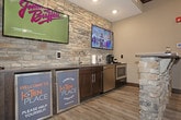 This single-story commercial space is thoughtfully designed with a cohesive aesthetic that blends natural stone accents, dark espresso wood trim, and warm neutral tones throughout. The reception area serves as a welcoming focal point, anchored by a striking stacked-stone desk with a dark countertop. Multiple windows dressed with horizontal blinds allow natural light to fill the room, complemented by recessed lighting and a ceiling fan overhead. Light-toned luxury vinyl plank flooring runs consistently throughout the space, providing both durability and visual continuity.

Dark-stained, paneled interior doors with modern hardware define the entrances to various rooms, lending a polished, upscale feel. A well-appointed kitchenette features dark cabinetry, a stainless steel sink, countertop appliances, and wall-mounted televisions set against a dramatic full stacked-stone accent wall, adding texture and visual interest. The hallway connects multiple rooms, including what appears to be a dedicated fitness area visible at the corridor's end, outfitted with exercise equipment. Crown molding and dark baseboards throughout tie each area together, creating a refined and professional environment well-suited for a business or service-oriented use.