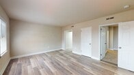 This efficient 490 square foot apartment in Presidential Greens offers a surprising three bedrooms and one bathroom within its compact layout. The space is thoughtfully designed to maximize functionality, with the primary bedroom boasting an impressive 220 square feet.

The apartment features a mix of flooring types, with plush carpeting in some bedrooms providing comfort underfoot, while sleek hardwood floors in the living areas and kitchen add a modern touch. The kitchen, though compact, is well-equipped with updated appliances including a stainless steel stove and built-in microwave. A stylish backsplash of linear tiles complements the clean, white cabinetry.

The bathroom showcases gleaming white tiles from floor to ceiling, creating a bright and hygienic space. A combination bathtub and shower meets diverse bathing needs. Throughout the apartment, large windows allow natural light to flood in, enhancing the sense of space and providing pleasant views of the surroundings.

Despite its modest square footage, the apartment maintains an open feel with strategically placed doors and archways connecting the various rooms. The neutral color palette of whites and beiges contributes to a fresh, contemporary ambiance that serves as a blank canvas for personal decorating styles.