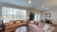 Located at Enclave Village Place in Lewis Center, Ohio, this multi-level residence spans three floors and offers a thoughtfully designed layout with comfortable living spaces throughout. The main level greets visitors with a bright, open living room featuring large windows that allow generous natural light to fill the space, complemented by hardwood-style flooring, crown molding, and a sliding glass door that connects to outdoor areas. Adjacent to the living room is a dedicated dining area with hardwood-style flooring, crown molding, and access to the kitchen, which is equipped with dark granite countertops, warm wood cabinetry, and black appliances including a range, microwave, and refrigerator. A convenient half bathroom is also located on this level. The upper floor is home to a generously sized primary bedroom featuring soaring ceilings, plush carpeting, dual closets, and a private ensuite. An additional full bathroom on this level includes a tiled tub-shower combination, warm wood vanity, and stone-look tile flooring. The lower level provides additional flexible living space with a cozy lounge area and a well-appointed bedroom with soft carpeting, offering ideal accommodations for guests or extended use. Throughout, neutral tones and classic finishes create a cohesive and inviting atmosphere across all three floors.