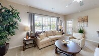 Located at 1461 Jag Branch Blvd in Kernersville, NC, this single-story residence offers a well-planned layout with a warm, neutral color palette throughout. The living room is a comfortable and inviting space, featuring large windows with blinds and elegant drape panels that allow abundant natural light to fill the room. Ceiling fans are present in multiple rooms for added comfort. The kitchen is well-appointed with warm wood cabinetry, granite-style countertops, stainless steel appliances including a refrigerator and range, tile flooring, and track lighting overhead. The dining area sits adjacent to the living space and benefits from access to natural light via a nearby exterior door. Multiple bedrooms are carpeted and feature ceiling fans and windows; the primary bedroom showcases generous space with room for a full dresser and nightstands. The bathrooms are finished with granite-topped vanities, wood cabinetry, tile flooring, and large mirrors. A dedicated laundry room houses a full-size washer and dryer. Throughout the home, consistent warm beige tones and tasteful finishes create a cohesive and comfortable living environment.