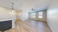 This well-appointed 1-bedroom, 1-bathroom residence in Northglenn, Colorado offers a thoughtfully designed single-floor layout with modern finishes throughout. The open-concept kitchen and living area serves as the heart of the home, featuring light wood-style flooring, a ceiling fan, and multiple windows that invite abundant natural light. The kitchen is a standout, showcasing a granite-topped island with an undermount sink, sleek two-tone cabinetry in dark and white, stainless steel appliances, subway tile backsplash, and elegant globe pendant lighting. The living area extends to a private balcony, providing an outdoor retreat. The bedroom is a comfortable and serene space with plush carpeting, a ceiling fan, and a window with exterior views. It connects directly to the bathroom, which features a glass-enclosed walk-in shower with white tile surround and a built-in marble bench. Generous storage is provided through three closets, including a walk-in closet with built-in shelving and double hanging rods. A dedicated laundry room houses a full-size Whirlpool washer and dryer. The neutral color palette and clean architectural lines create a cohesive, move-in-ready environment throughout.