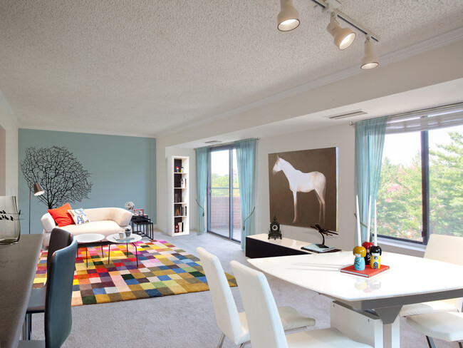 Living and dining areas with accent wall, balcony access and carpeted flooring - Avalon at Foxhall