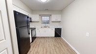 Located at 9113 Cox Ct in Louisville, KY, this single-floor unit offers a clean, neutral aesthetic throughout. The layout flows logically from room to room, as visible in the 3D floor plan, with clearly defined living, kitchen, bedroom, and bathroom areas.

The living room is a generously sized space finished with plush grey carpet and warm beige walls. A sliding glass door fitted with vertical blinds fills the room with natural light and opens to a private balcony with exterior views of the surrounding community.

The kitchen features updated white shaker-style cabinetry paired with marble-look countertops and wood-tone luxury vinyl plank flooring. Black appliances — including a refrigerator, range with over-the-range microwave, and dishwasher — provide a striking contrast. A window above the sink allows for additional natural light.

The bedrooms are carpeted and spacious, each featuring closets with bifold doors. One bedroom includes a ceiling fan, adding to overall comfort. Neutral tones throughout keep the rooms feeling bright and adaptable.

The bathroom offers a full tub and shower combination surrounded by clean white tile, providing a simple and functional finish. Overall, the space presents a well-maintained, move-in ready environment.