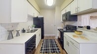 Located at 11910 Thoroughbred Dr in Houston, Texas, this single-story residence offers a well-organized layout with consistent wood-look flooring throughout, creating a cohesive and easy-to-maintain living environment.

The kitchen is a standout feature, designed as a galley-style space lined with white cabinetry, subway tile backsplash, and light countertops that contrast cleanly against black appliances, including a refrigerator, electric range with overhead microwave, and dishwasher. A peninsula with bar seating extends into the adjoining area, providing additional prep space and casual dining options. A stainless steel sink and overhead range hood complete the functional setup.

The open living and dining area flows naturally from the kitchen, offering a flexible, unobstructed layout illuminated by ceiling-mounted lighting and serviced by a central HVAC vent. Ceiling fans are present in the main living areas, contributing to comfortable year-round climate control.

The bedroom is a calm, well-proportioned room featuring a ceiling fan with light fixture and a window dressed with dark curtains, allowing for controlled natural light.

The bathroom is neatly appointed with a tub-shower combination, vanity with storage, and wood-look flooring that matches the rest of the home, maintaining design continuity throughout the space.