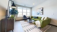 This contemporary 860-square-foot apartment in Milwaukee offers a harmonious blend of style and functionality. The open-concept living area is bathed in natural light from large windows, creating an airy ambiance. The living room features a comfortable green sofa, modern furnishings, and a stylish area rug, perfect for relaxation or entertaining.

The kitchen boasts sleek dark cabinetry, stainless steel appliances, and a convenient island, ideal for meal preparation or casual dining. The bedroom, measuring 140 square feet, is tastefully decorated with modern artwork and ample storage space. Two well-appointed bathrooms feature elegant finishes, including dark vanities and large mirrors.

An additional office space provides a dedicated work area, complete with a desk and decorative shelving. The apartment also includes two closets for storage and in-unit laundry facilities. Throughout the space, neutral tones and wood-look flooring create a cohesive, contemporary aesthetic.

Located at 145 E Becher St in Milwaukee, this single-floor apartment combines urban living with modern comforts, offering a stylish and efficient living space in the heart of the city.