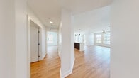 Located along Las Vegas Blvd in Las Vegas, NV, this well-appointed 2-bedroom, 2-bathroom residence offers a thoughtfully designed single-level layout with modern finishes throughout. Light wood-tone flooring runs seamlessly across the entire space, creating a warm and cohesive aesthetic.

The open-concept kitchen and living area serves as the heart of the home. The kitchen is outfitted with stainless steel appliances, including a French door refrigerator, gas range, microwave, and dishwasher. Sleek two-tone cabinetry — white uppers paired with dark wood lowers — is complemented by a white countertop island with pendant lighting above, providing both prep space and a casual dining option.

Both bedrooms are bright and well-sized, featuring ceiling fans, large windows that bring in natural light and community views, and clean white walls. The primary bedroom connects to a full bathroom and walk-in closet with built-in shelving. The second bathroom mirrors the same contemporary design, featuring a soaking tub with tiled surround, a dark wood vanity with a white countertop, and an illuminated mirror. A hallway and additional closet space complete the functional layout of this clean, move-in-ready residence.