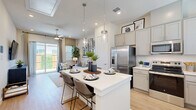 Located at 322 W Melissa Rd in Melissa, TX, this single-story, one-bedroom, one-bathroom home offers a smartly designed open-concept layout that maximizes every square foot. Light wood-look flooring flows throughout, complemented by crisp white walls and recessed lighting that create a bright, airy ambiance.

The kitchen is a standout feature, showcasing gray shaker-style cabinetry extending to the ceiling, white quartz countertops, a subway tile backsplash, and a full suite of stainless steel appliances including a French door refrigerator, range, microwave, and dishwasher. A central island with pendant lighting and bar seating connects seamlessly to the open dining and living areas.

The living room benefits from natural light and sliding glass doors that open to a private outdoor patio. A ceiling fan adds comfort, while the open sightlines make the space feel expansive.

The bedroom is a peaceful retreat with large windows, soft natural light, and direct access to a walk-in closet with built-in shelving and hanging rods. The bathroom features gray vanity cabinetry, a white quartz countertop, and a glass-enclosed shower. Additional conveniences include a dedicated laundry area and pantry, rounding out this thoughtfully appointed home.