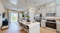 Located at 322 W Melissa Rd in Melissa, TX, this single-story, one-bedroom, one-bathroom home offers a smartly designed open-concept layout that maximizes every square foot. Light wood-look flooring flows throughout, complemented by crisp white walls and recessed lighting that create a bright, airy ambiance.

The kitchen is a standout feature, showcasing gray shaker-style cabinetry extending to the ceiling, white quartz countertops, a subway tile backsplash, and a full suite of stainless steel appliances including a French door refrigerator, range, microwave, and dishwasher. A central island with pendant lighting and bar seating connects seamlessly to the open dining and living areas.

The living room benefits from natural light and sliding glass doors that open to a private outdoor patio. A ceiling fan adds comfort, while the open sightlines make the space feel expansive.

The bedroom is a peaceful retreat with large windows, soft natural light, and direct access to a walk-in closet with built-in shelving and hanging rods. The bathroom features gray vanity cabinetry, a white quartz countertop, and a glass-enclosed shower. Additional conveniences include a dedicated laundry area and pantry, rounding out this thoughtfully appointed home.