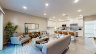 Located at 1470 S Santa Fe Ave in Vista, CA, this two-story home is designed with a clean, contemporary aesthetic throughout. The main level centers around an open-concept living and kitchen area, where the living room flows seamlessly into the dining space and kitchen. The kitchen is well-appointed with crisp white shaker cabinetry extending to the ceiling, light quartz countertops, stainless steel appliances including a gas range with microwave above and a French door refrigerator, and an island with bar seating. Recessed lighting illuminates the space, which features neutral tile flooring. The living room offers sliding glass door access to a private outdoor patio, filling the room with natural light. Bathrooms throughout the home are finished with white vanity cabinetry, quartz countertops, and tile flooring, with one bath featuring a glass-enclosed walk-in shower. The generously sized primary suite on the upper level includes warm wood-tone flooring, multiple windows for abundant natural light, a walk-in closet, and an en-suite bath. An attached two-car garage with an automatic opener provides convenient parking and additional storage. The home maintains a cohesive, neutral color palette that lends a bright and welcoming atmosphere throughout.