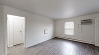Located at 344 Firwood Dr in Dayton, Ohio, this single-floor unit offers a clean, modern aesthetic throughout. The interior is finished with durable gray vinyl plank flooring that flows consistently across the living areas and bedrooms, contributing to a cohesive and contemporary look.

The kitchen stands out as a highlight of the space, featuring white shaker-style cabinetry, granite countertops with a subtle speckled pattern, a deep stainless steel sink with a pull-down faucet, and a classic white subway tile backsplash. Stainless steel appliances complete the functional and stylish kitchen setup.

The living and sleeping areas are bright and open, with white walls, natural light provided by double-hung windows with blinds, and baseboard heating units running along the walls. A wall-mounted air conditioning unit is present in one of the rooms, and a closet with double doors provides convenient built-in storage.

The bathroom is clean and well-appointed, featuring a full soaking tub with a shower, a curved brushed nickel curtain rod, a white vanity, and vinyl plank flooring that ties into the rest of the unit. The overall layout, as seen in the dollhouse view, is compact yet efficiently organized, with clear transitions between the kitchen, living area, bedroom, and bathroom.