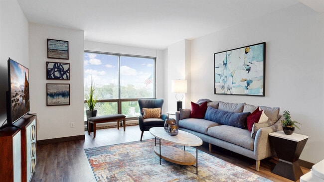 Large windows invite natural light, creating a bright and airy living space. - Midtown Crossing Apartments