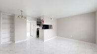 Located at 8600 S Course Dr in Houston, TX, this single-story, one-bedroom, one-bathroom unit offers a well-organized layout designed to maximize every square foot of living space. Polished marble-look porcelain tile flows consistently throughout the entire unit, lending a clean and cohesive aesthetic from room to room.

The open-concept living area connects seamlessly to the kitchen via a peninsula counter, creating an efficient and social layout. The galley-style kitchen is thoughtfully equipped with granite countertops, a double stainless steel sink, gray cabinetry, a tile backsplash, and black appliances including a range and refrigerator. A pass-through counter adds visual openness between the kitchen and living space.

The bedroom is a well-proportioned retreat featuring two windows that invite natural light and offer outdoor views. A ceiling fan enhances comfort, and a closet provides dedicated storage. The neutral warm-toned walls complement the bright flooring throughout.

The bathroom is efficiently designed with a granite-topped vanity, gray cabinetry, a full tub/shower combination with white tile surround, and matching marble-look tile flooring. The overall palette of the unit — warm greige walls, white trim, and light flooring — creates a bright, neutral atmosphere that is easy to personalize.